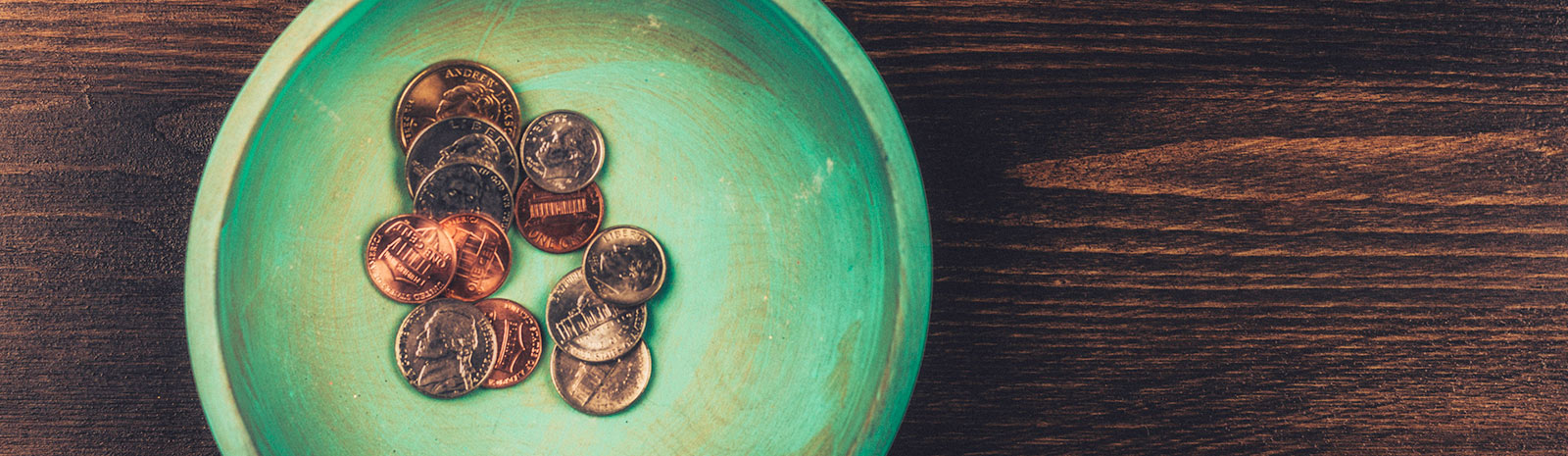 a handful of coins inside a bowl