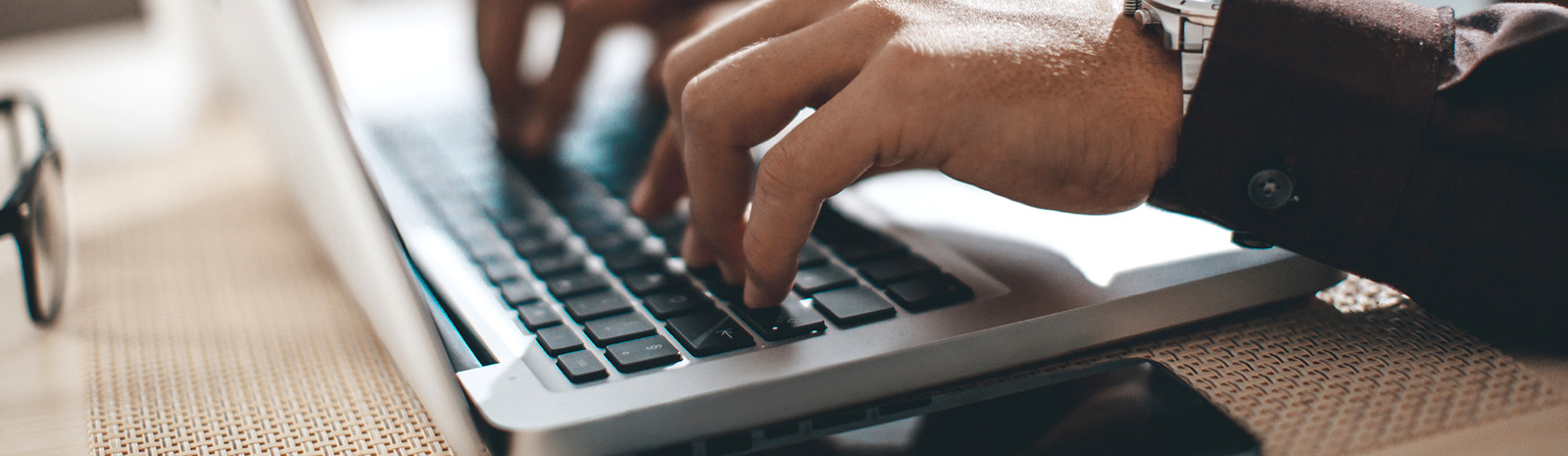 a close up of a person's hands using a laptop